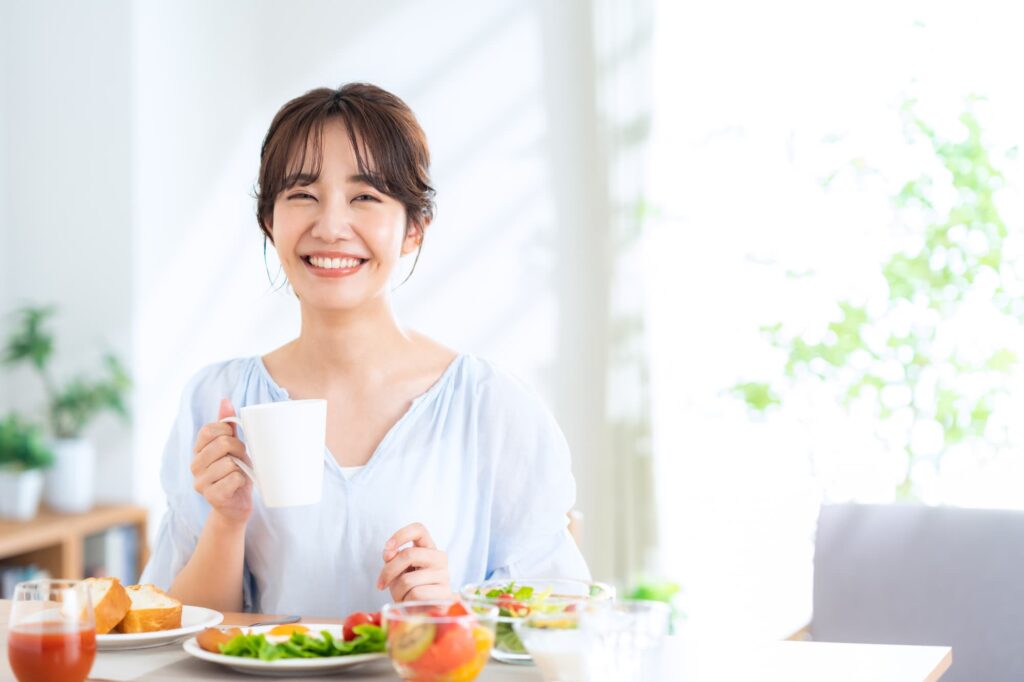 インプラントで綺麗になった歯で食事を楽しむ女性